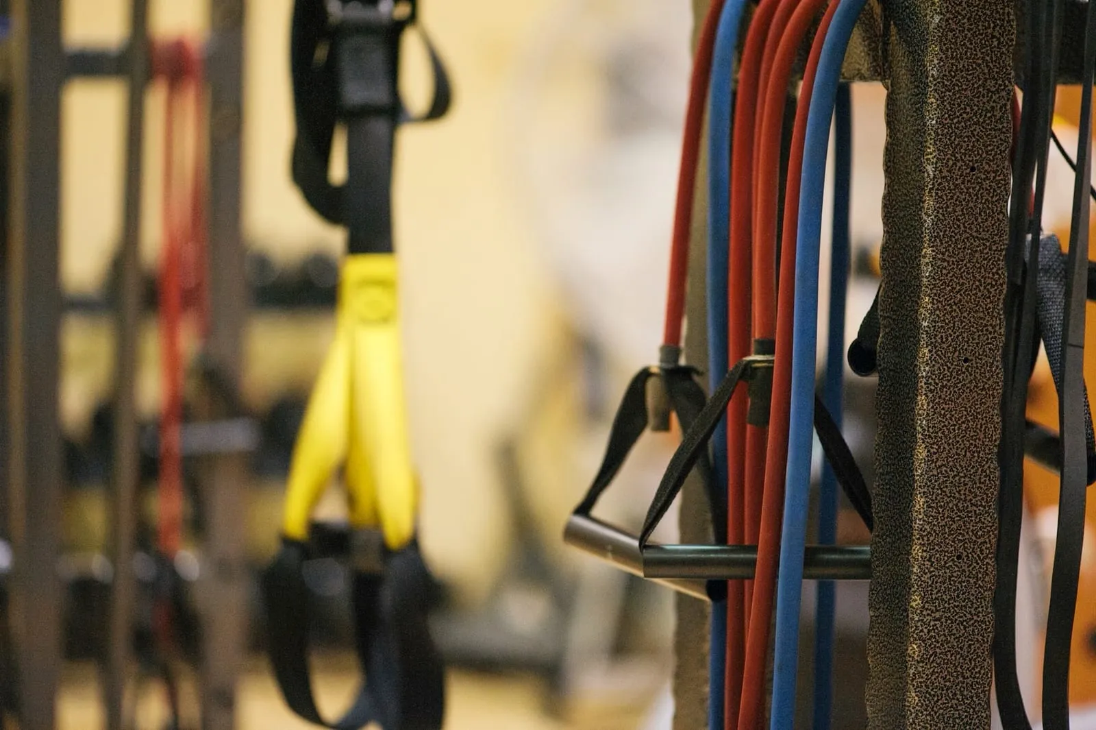 Resistance bands and suspension trainers hanging on a rack.